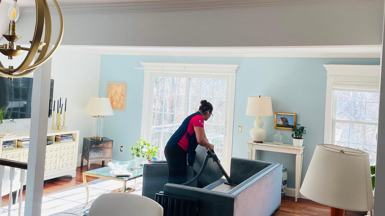A Nissi's Cleaning Service team member vacuuming a living room in Westchester County